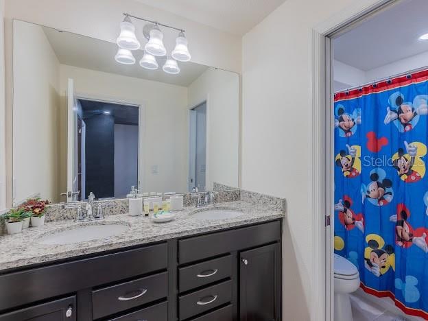 bathroom with vanity, toilet, and curtained shower