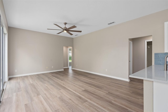 unfurnished living room with ceiling fan and light hardwood / wood-style flooring