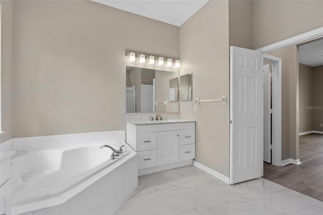 bathroom featuring vanity and tiled bath