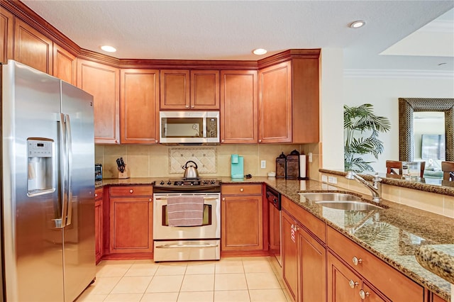 kitchen with stone countertops, stainless steel appliances, sink, light tile patterned floors, and tasteful backsplash