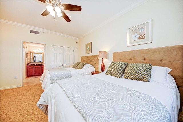 carpeted bedroom with a closet, ornamental molding, ensuite bath, and ceiling fan