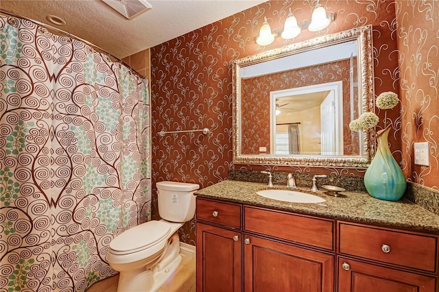 bathroom featuring toilet, a textured ceiling, a shower with curtain, and vanity