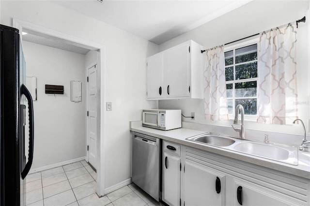 kitchen with white cabinetry, dishwasher, sink, black fridge, and light tile patterned floors