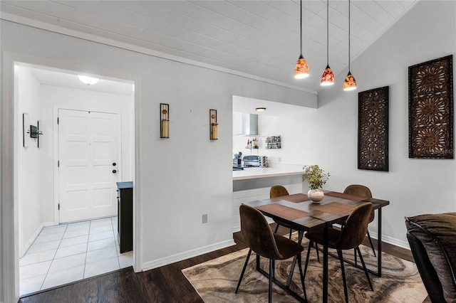 dining space with light hardwood / wood-style flooring and vaulted ceiling