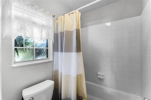 bathroom featuring shower / tub combo and toilet