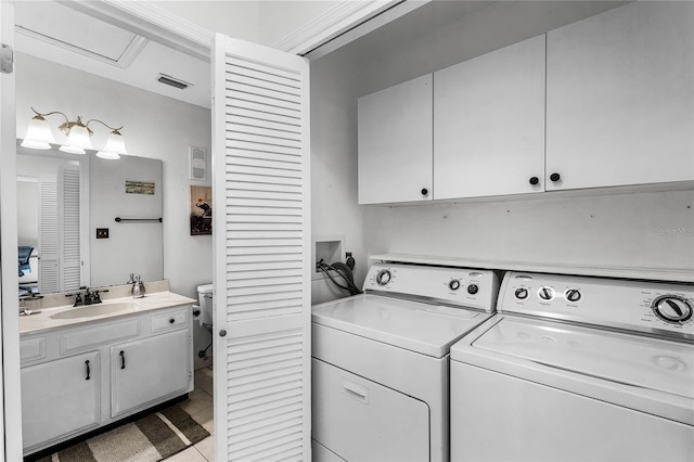 laundry area with cabinets, light tile patterned floors, washing machine and dryer, and sink