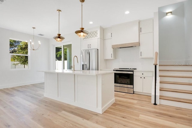 kitchen featuring pendant lighting, white cabinets, sink, light hardwood / wood-style flooring, and stainless steel appliances