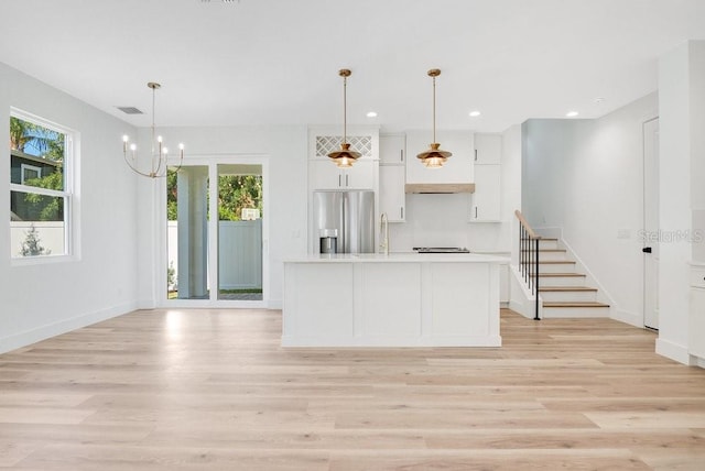 kitchen with light hardwood / wood-style flooring, stainless steel fridge, and plenty of natural light