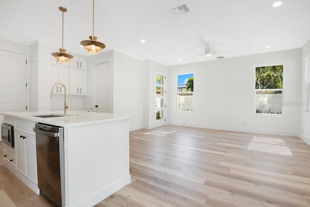 kitchen featuring pendant lighting, stainless steel dishwasher, white cabinetry, and a healthy amount of sunlight