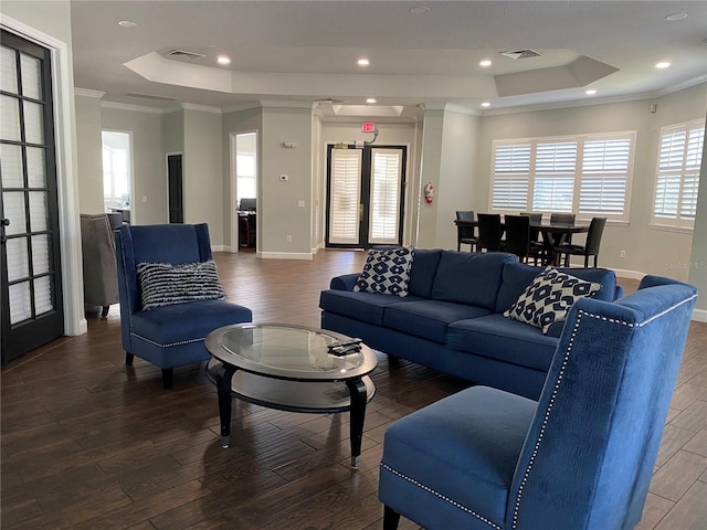 living room with french doors, a raised ceiling, ornamental molding, and dark wood-type flooring