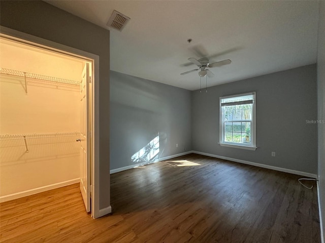 unfurnished bedroom featuring ceiling fan, a closet, and hardwood / wood-style flooring