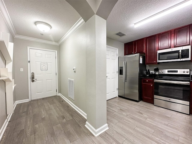 kitchen featuring appliances with stainless steel finishes, crown molding, a textured ceiling, and light hardwood / wood-style floors