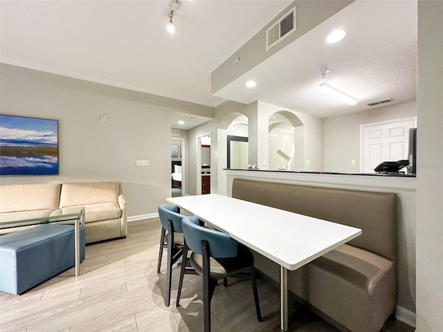 dining room featuring a textured ceiling and light hardwood / wood-style flooring