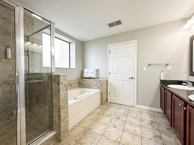 bathroom with vanity, separate shower and tub, a textured ceiling, and tile patterned flooring