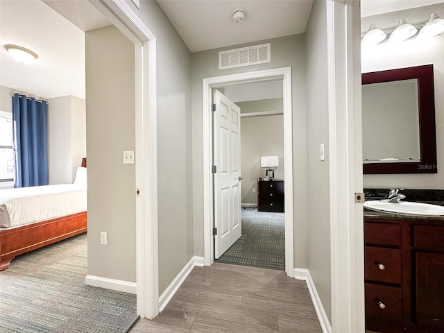 hall with sink and light wood-type flooring