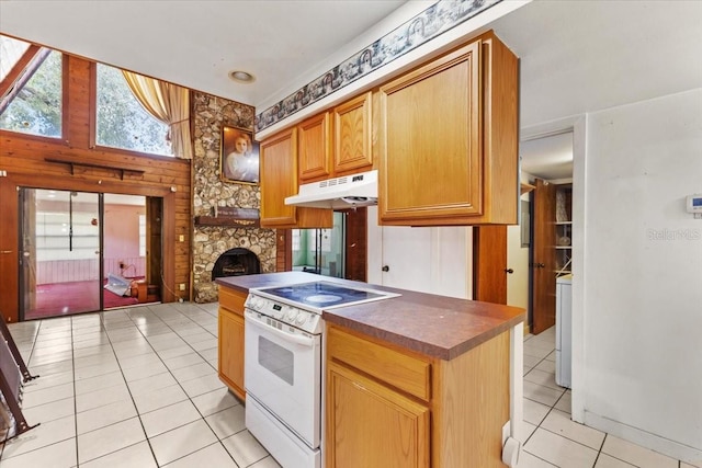 kitchen with a stone fireplace, washer / clothes dryer, light tile patterned flooring, and white range with electric cooktop