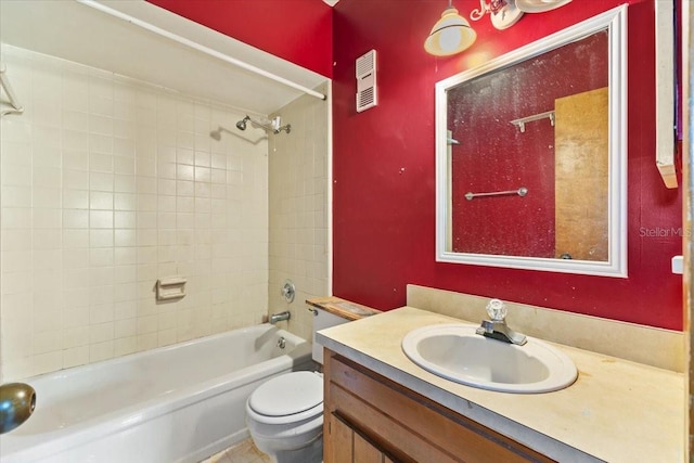 full bathroom featuring vanity, tiled shower / bath combo, and toilet