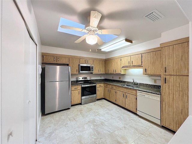 kitchen with appliances with stainless steel finishes, sink, and ceiling fan