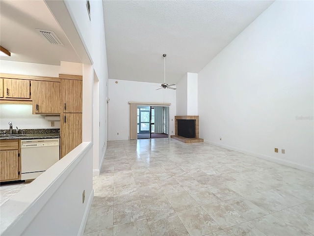 kitchen featuring ceiling fan, a textured ceiling, high vaulted ceiling, dishwasher, and sink