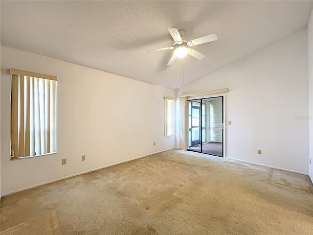 carpeted spare room with ceiling fan, a textured ceiling, and lofted ceiling