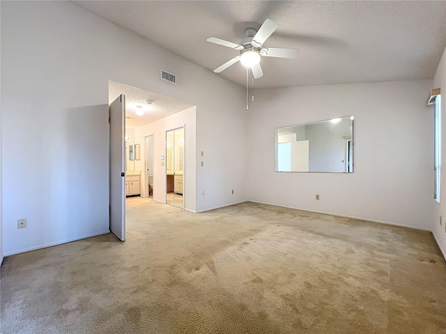 carpeted empty room featuring ceiling fan, a textured ceiling, and vaulted ceiling