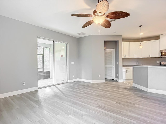 unfurnished living room featuring ceiling fan and light wood-type flooring