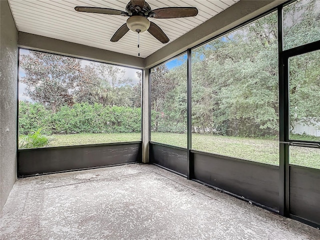 unfurnished sunroom with ceiling fan, wooden ceiling, and a wealth of natural light