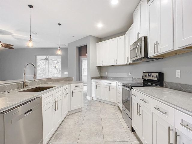 kitchen with sink, white cabinets, decorative light fixtures, appliances with stainless steel finishes, and ceiling fan