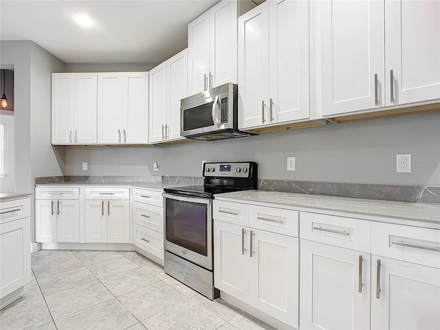 kitchen featuring light stone countertops, white cabinetry, and stainless steel appliances