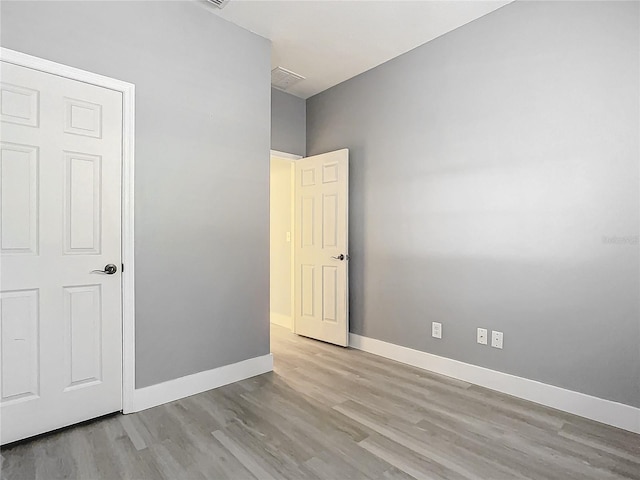 empty room with light hardwood / wood-style flooring