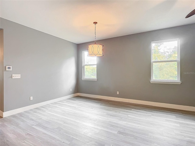 spare room featuring light hardwood / wood-style floors, plenty of natural light, and ceiling fan