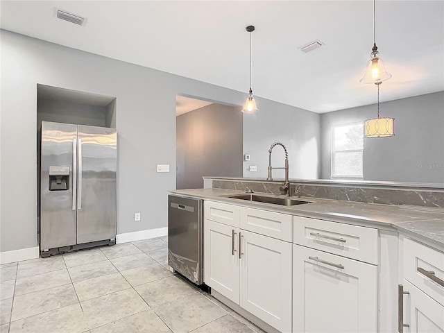 kitchen featuring stainless steel counters, sink, white cabinets, pendant lighting, and appliances with stainless steel finishes