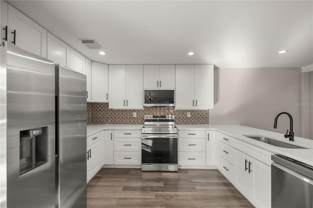 kitchen with stainless steel appliances, sink, dark hardwood / wood-style flooring, and white cabinetry