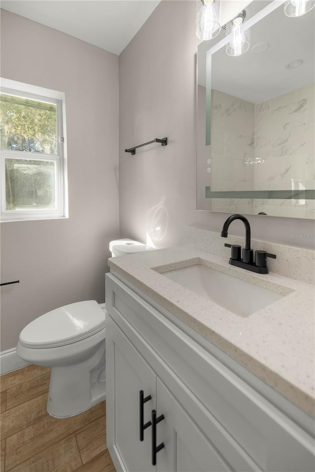 bathroom featuring hardwood / wood-style flooring, vanity, and toilet