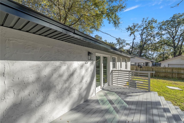 wooden deck featuring a lawn