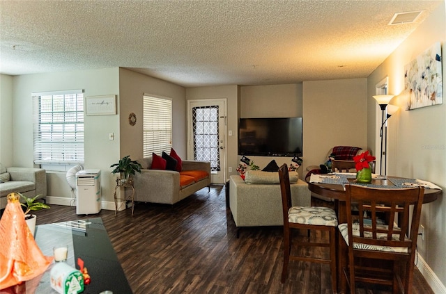 living room with dark hardwood / wood-style floors and a textured ceiling