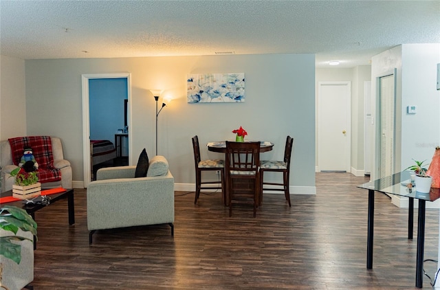 dining room featuring dark hardwood / wood-style floors and a textured ceiling