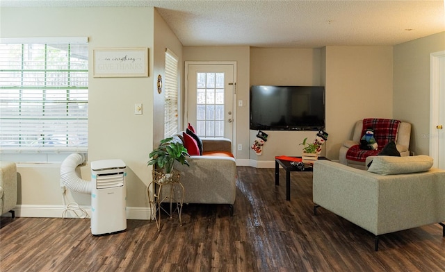 living room featuring dark wood-type flooring and a textured ceiling