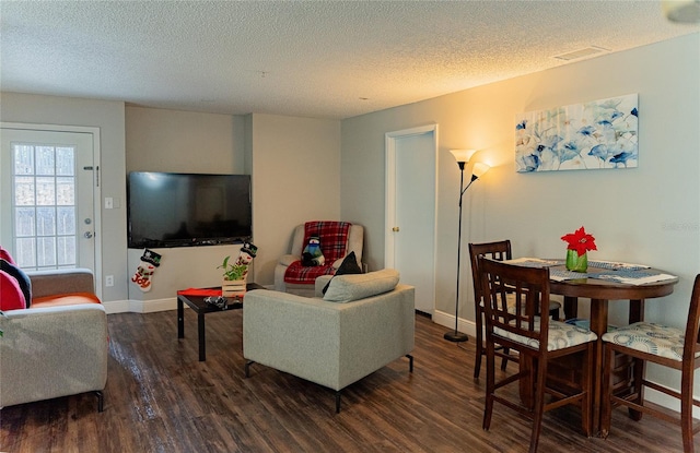 living room featuring dark wood-type flooring and a textured ceiling