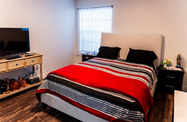 bedroom with dark hardwood / wood-style flooring