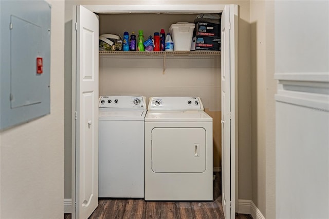 clothes washing area with electric panel, washing machine and clothes dryer, and dark hardwood / wood-style flooring