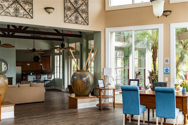 interior space featuring ceiling fan, dark wood-type flooring, and a high ceiling