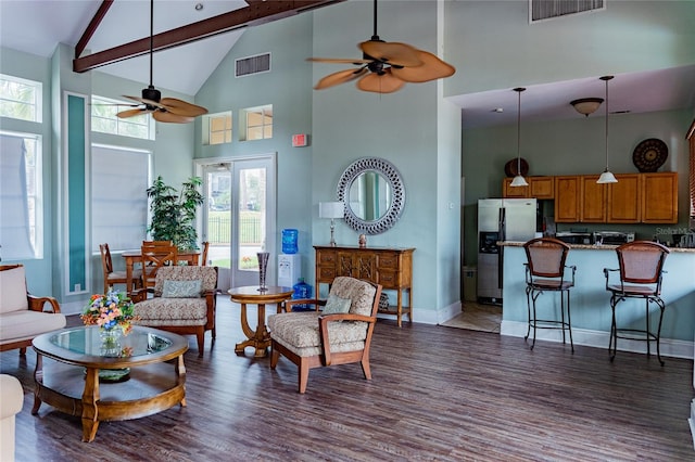 living room with dark hardwood / wood-style floors, beam ceiling, high vaulted ceiling, and a healthy amount of sunlight