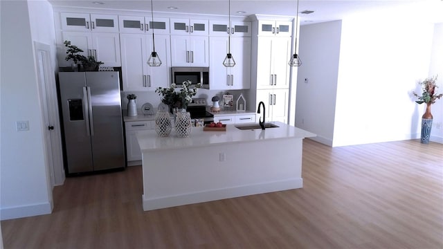 13356 SW 64th Street Rd, Ocala, FL 34482 - kitchen featuring stainless steel appliances, a sink, a kitchen island with sink, white cabinets, and wood finished floors