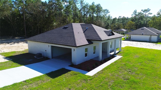 13356 SW 64th Street Rd, Ocala, FL 34482 - rear view of house featuring a shingled roof, a garage, driveway, central air condition unit, and stucco siding