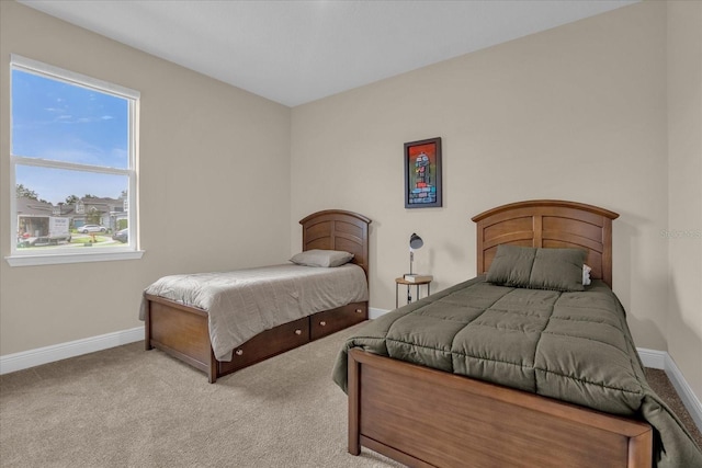 bedroom featuring light colored carpet and multiple windows