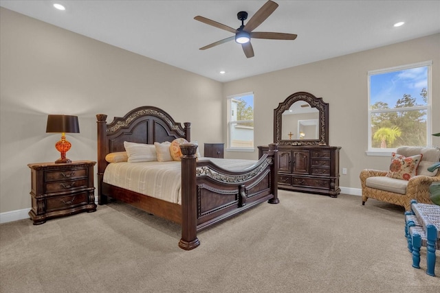 bedroom with multiple windows, ceiling fan, and light colored carpet