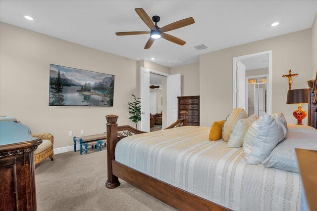 carpeted bedroom featuring ceiling fan and ensuite bathroom