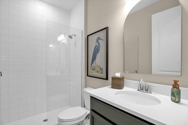 bathroom featuring vanity, tiled shower, and toilet