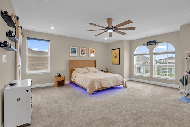 carpeted bedroom featuring multiple windows and ceiling fan